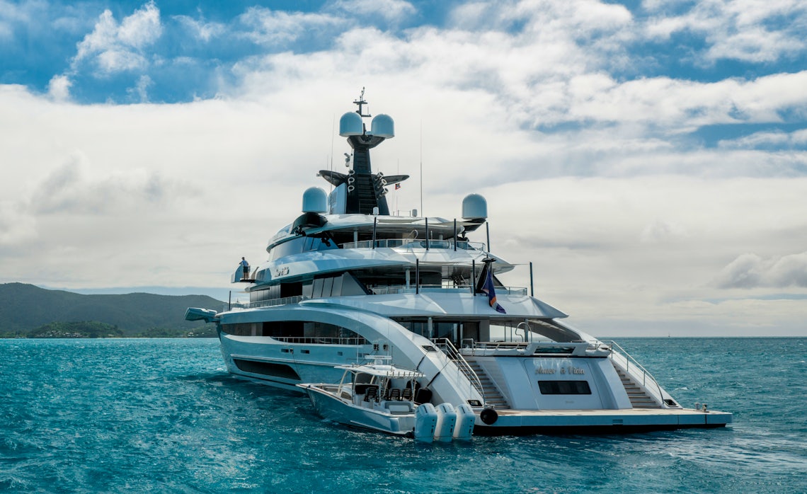 The Stern of a Yacht on Beautiful Blue Waters with a Smaller Boat Next to it