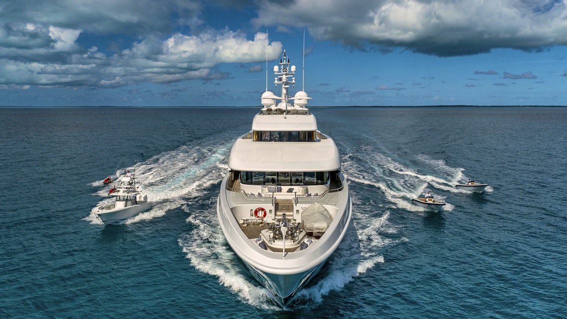 Yacht Facing Forward with Smaller Boats Flanking its Sides